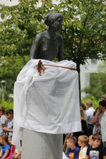 Deklica z Rastočo knjigo z verzi Saše Vegri in kip azerbajdžanskega pesnika Nizamija Ganjavija 
